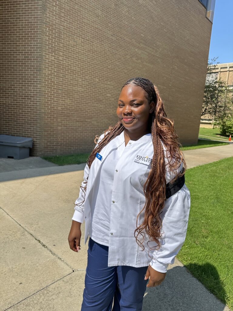 Jachimike Peter-Afunanya stands outside Henderson Hall on the Kent Campus in her Kent State nursing uniform.